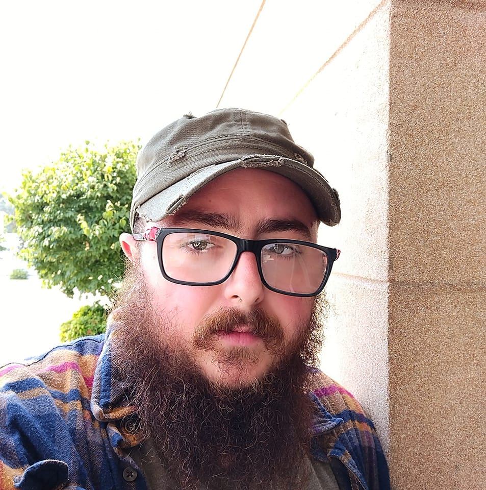 A photo of me. White male. Beard. Large frame glasses. Green cap.